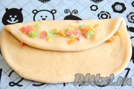 Сначала накрыть цукаты одной половинкой теста, выложить полоску цукатов (как на фото), а затем накрыть второй частью теста, снова выложить цукаты. Получится трёхслойная полоска.