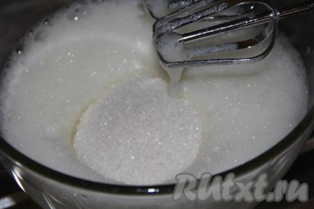 Для приготовления ванильного бисквита разделить яйца на желтки и белки. Белки взбить миксером в пышную пену, затем всыпать сахар и ванильный сахар.