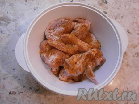 Порционные части курицы хорошо посыпать приправой, посолить, перемешать.