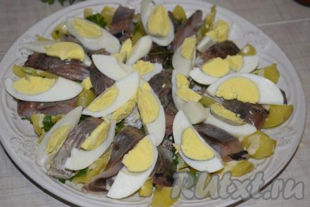 Сверху раскладываем яйца и опять поливаем 2 столовыми ложками заправки.