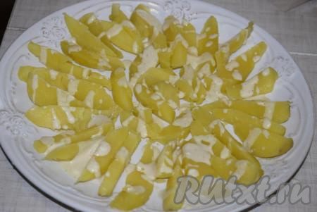 Картошку чуть-чуть присаливаем и поливаем, примерно, 2 столовыми ложками приготовленной заправки.