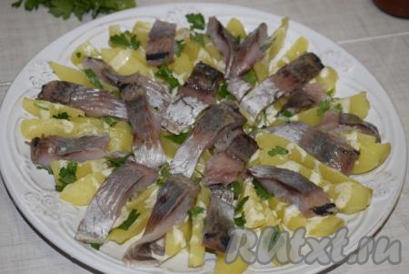 Далее выкладываем селедку и снова поливаем 2 столовыми ложками заправки.