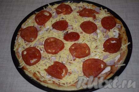 Пиццу с шампиньонами и колбасой посыпаем сыром, натертым на крупной терке, сверху выкладываем помидоры, нарезанные на кружочки.