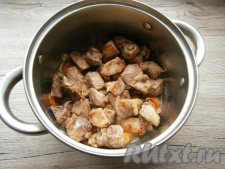 На сковороду налить 2-3 столовые ложки растительного масла, добавить кусочки свинины, обжарить их на среднем огне до небольшой румяности со всех сторон, затем выложить мясо&nbsp;в кастрюлю поверх овощей.