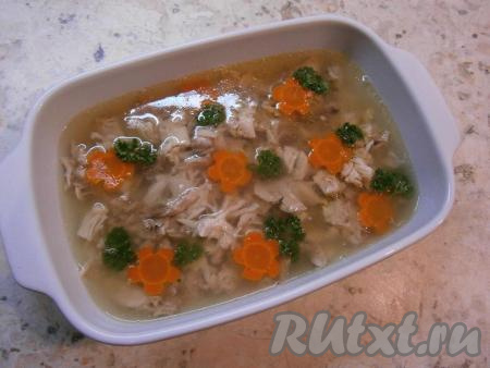 Дать курице с бульоном полностью остыть, украсить веточками зелени. Поместить заливное в холодильник на несколько часов или на ночь (до полного застывания).