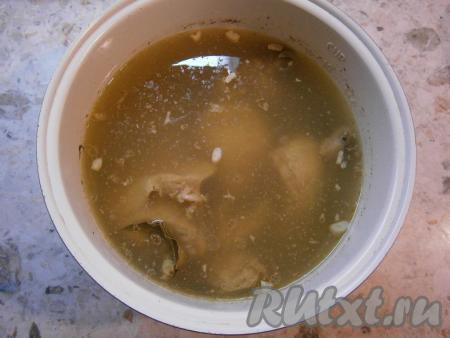 Поместить чашу в мультиварку, выставить режим "Холодец" на 3 часа, крышку закрыть. Когда вода закипит (примерно, через 1,5 часа), аккуратно снять пену, бульон посолить по вкусу. Закрыть крышку и варить далее. За 20&nbsp;минут до сигнала вынуть морковь и положить на тарелку, добавить в бульон лавровые листья и измельченный чеснок.&nbsp;