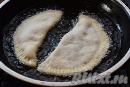 Выкладываем подготовленные чебуреки на разогретую сковороду с большим количеством растительного масла и жарим их с обеих сторон на среднем огне, примерно, по 3-4 минуты с каждой стороны.