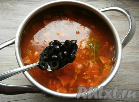 Выложить в сборную мясную солянку нарезанные колечками черные оливки, перемешать, варить на слабом огне 10 минут.