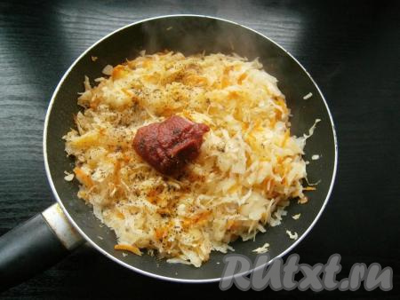 Жарить капусту на небольшом огне, перемешивая, минут 5-6, чтобы она немного обмякла. Затем добавить томатную пасту, специи, сахар и черный молотый перец,&nbsp;влить воду. Тщательно перемешать.