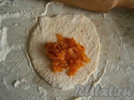 Каждую часть теста немного раскатать. Выложить в центр раскатанного теста столовую ложку капусты.