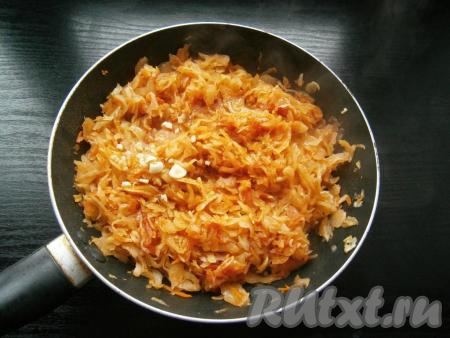 Тушить капусту на небольшом огне, периодически ее перемешивая, около 10 минут. В конце добавить измельченный очищенный чеснок, перемешать.