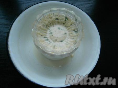 Творог поместить в пластиковую емкость (например, в обрезанную пластиковую бутылку) с дырочками на дне (дырочки на дне ёмкости нужны для того, чтобы через них стекала оставшаяся сыворотка). Поставить под пластиковую ёмкость тарелку, чтобы в неё стекала сыворотка. Поверх творога поставить небольшой гнет. 