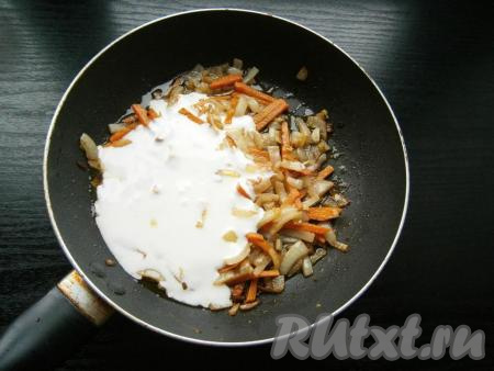 Дать овощам немного остыть, затем влить в сковороду смесь сметаны и воды.