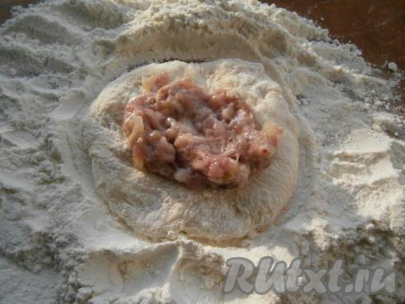 Немного тесто обвалять в муке, сформировать лепешку, в середину которой поместить 1 столовую ложку мясного фарша.