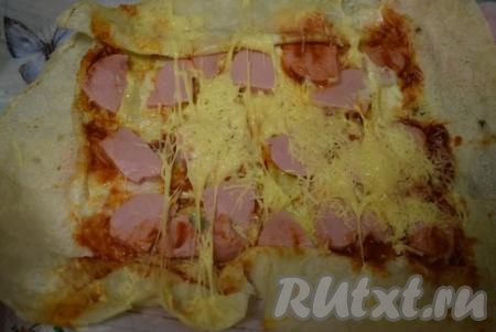 Достать шаурму с сыром и колбасой и развернуть ее.