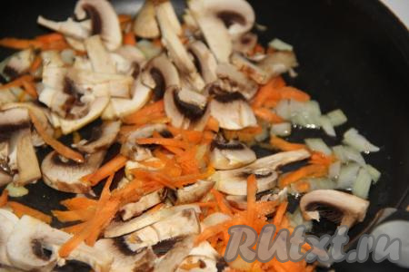 Добавить грибы в сковороду с морковкой и луком, обжаривать шампиньоны с овощами в течение 10 минут, иногда перемешивая.
