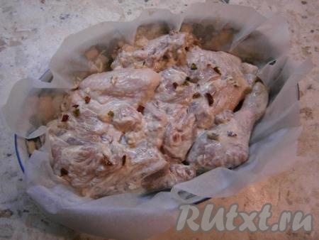 Форму для запекания застелить пергаментом и выложить курицу, чтобы кусочки лежали плотно друг к другу.