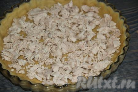 На тесто выложить куриную грудку, предварительно нарезанную или разобранную на волокна.