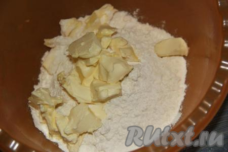 В глубокую миску просеять муку, добавить соль, разрыхлитель. Холодное масло порубить на кусочки и добавить в мучную смесь.