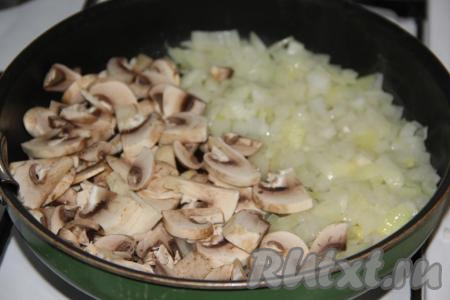 Добавить нарезанные шампиньоны в сковороду и обжарить вместе с луком в течение 10 минут.