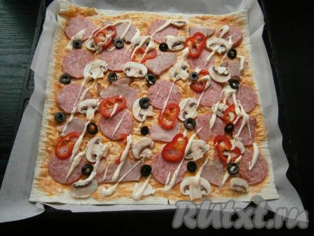 Далее выложить нарезанные колечками маслины. Поверх начинки смазать оставшимся майонезом, немного поперчить и посыпать итальянскими травами.