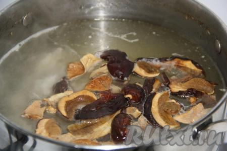 Добавить сушеные грибы и нарезанное куриное мясо в кипящий бульон. Варить грибы 25 минут на небольшом огне.