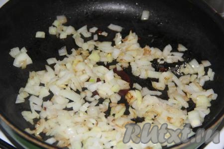 В сковороду добавить растительное масло, выложить мелко нарезанный очищенный лук, обжарить до золотистого цвета, помешивая, на среднем огне.