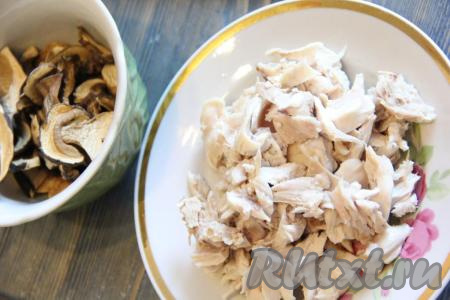 В кастрюлю влить 3 литра воды, добавить куриное мясо, поставить на огонь, после закипания снять пену, уменьшить огонь и варить минут 30. Затем вынуть мясо и нарезать на кусочки. Сушеные грибы промыть под проточной водой.