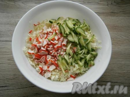 Добавить к пекинской капусте нарезанный брусочками свежий огурец и нарезанные крабовые палочки.