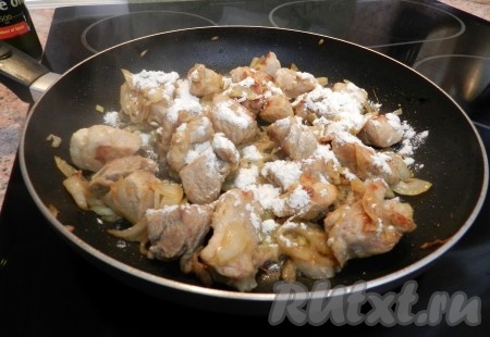Присыпать мясо с луком мукой, тщательно перемешать, чтобы мука равномерно распределилась по свинине и впиталась в неё.