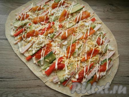 Болгарский перец, нарезанный на полоски, тоже разложить на лаваш, посыпать натертым вареным яйцом, немного поперчить и смазать оставшимся майонезом.