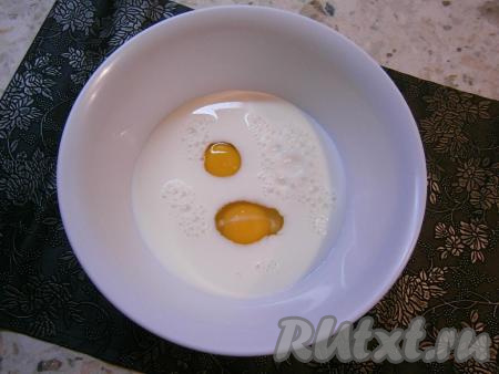В молоко комнатной температуры всыпать сахар и добавить сырые яйца.