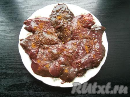 Отбитые кусочки печени посолить, посыпать специями и черным молотым перцем.