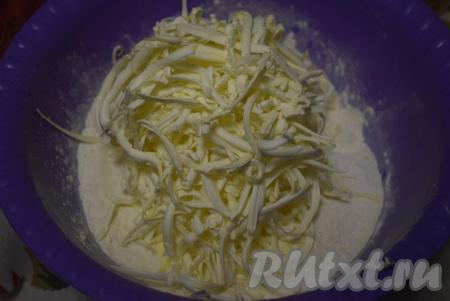 К муке добавляем охлажденное сливочное масло, натертое на крупной терке.