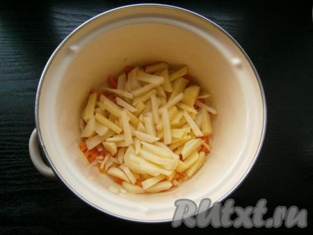 Обжарить лук с морковью прямо в кастрюле, перемешивая их, на небольшом огне. Затем добавить нарезанный брусочками картофель.