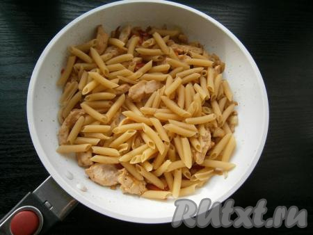 Обжаривать филе с овощами в течение 5-7 минут. Затем добавить в сковороду сухие макароны.