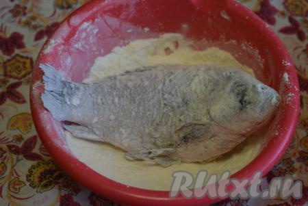 Сливаем выделившийся сок, образовавшийся от взаимодействия рыбы с солью. Далее в миску насыпаем муку и обваливаем в ней карасиков со всех сторон.