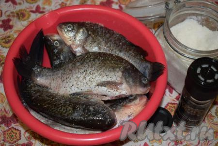 Промываем карасей еще раз и даем стечь воде. Подготовленную рыбу солим, перчим, втирая соль с перцем снаружи и внутри. Оставляем пропитаться, примерно, на 30 минут.