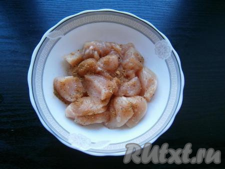 Куриное филе нарезать небольшими кусочками, посыпать солью, приправой и черным молотым перцем, перемешать.