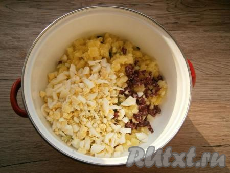 Добавить нарезанную небольшими кубиками колбасу и рубленные вареные яйца.