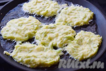 Выкладываем тесто столовой ложкой на сковороду с разогретым растительным маслом. Разравниваем тесто ложкой, придавая округлую форму нашим кабачковым оладьям.
