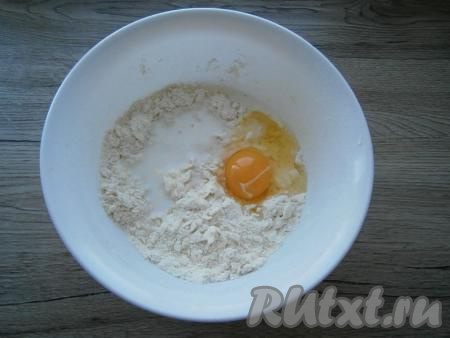 Перетереть руками получившуюся смесь в крошку, влить холодное молоко и добавить сырое яйцо.