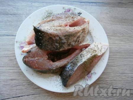 Посолить рыбу, посыпать щедро специями.