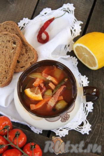 Подать вкусную и ароматную солянку, приготовленную с колбасой и картошкой, в горячем виде.