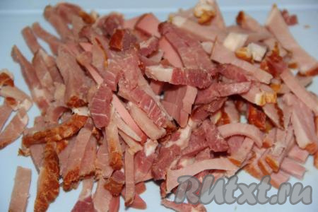 Колбасу или колбасно-мясное ассорти нарезать на длинные брусочки (небольшую часть нарезанных колбасных изделий отложить для обжарки).