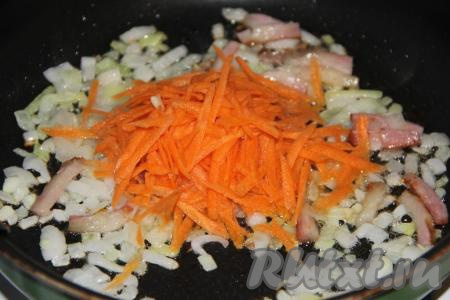 Морковь очистить, натереть на крупной тёрке, выложить на сковороду с колбасой и луком, обжарить в течение 3-5 минут, иногда помешивая.
