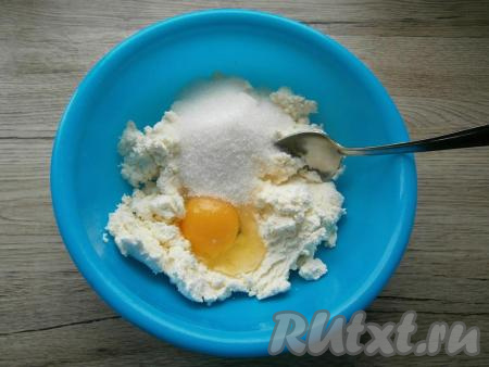 Для приготовления начинки в мягкий творог добавить сырое яйцо, всыпать сахар.