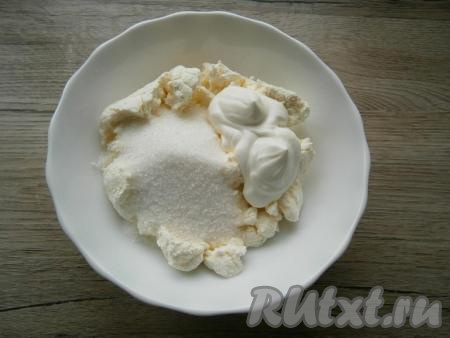 В творог добавить сметану и всыпать сахар, тщательно растереть или взбить погружным блендером творожную массу до однородности.