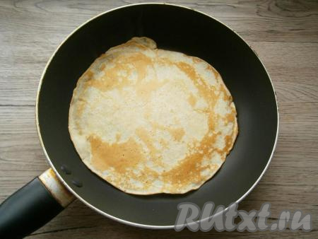 На сухую хорошо разогретую сковороду налить небольшое количество теста, равномерно распределяя его по поверхности сковороды. Жарить блинчик на среднем огне до румяного цвета с двух сторон. Аналогично пожарить все блины.