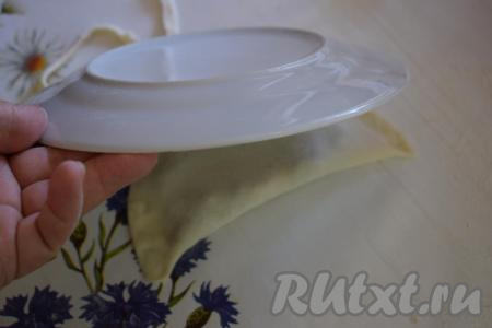 Тарелкой обрезаем чебурек по кругу (для придания ровной полукруглой формы).